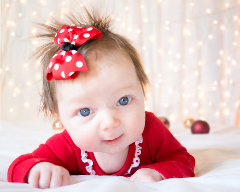 image of baby on bed with lights bokeh
