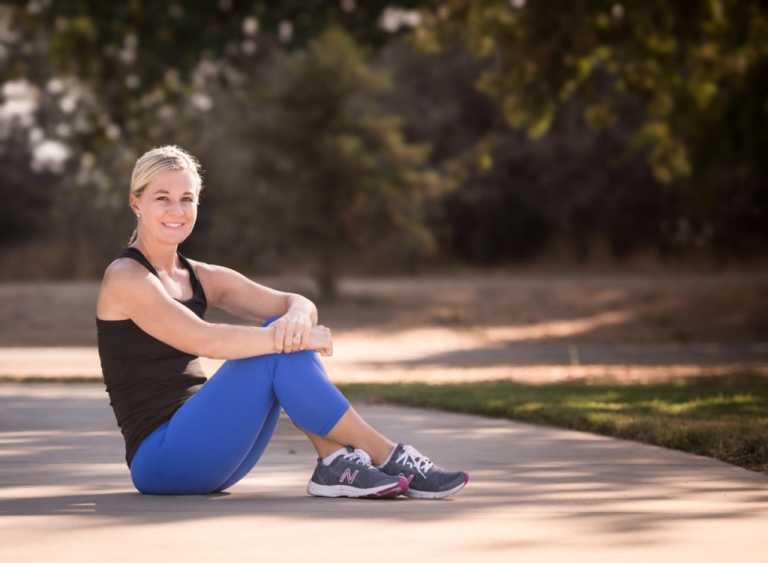 woman in workout clothes sitting on path