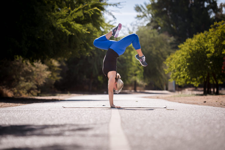 woman doing handstand on path