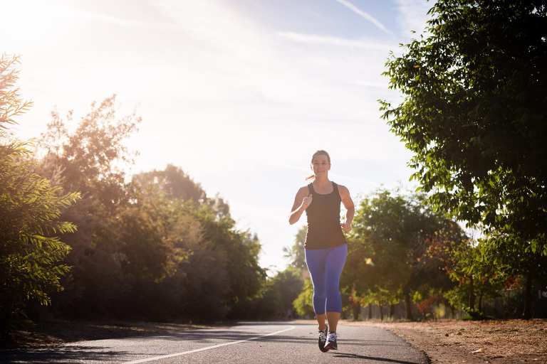 woman running in early morning light on pathway